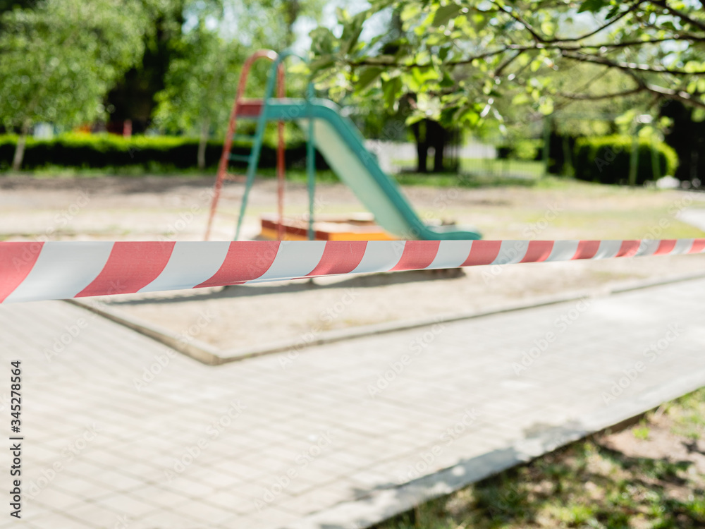 Park kids and children playground for game and activity empty and closed for Coronavirus or Covid19, tape and strips with word STOP, do not enter. Park kids and children playground for game and activity empty and closed for Coronavirus or Covid19, tape and strips with word STOP, do not enter.