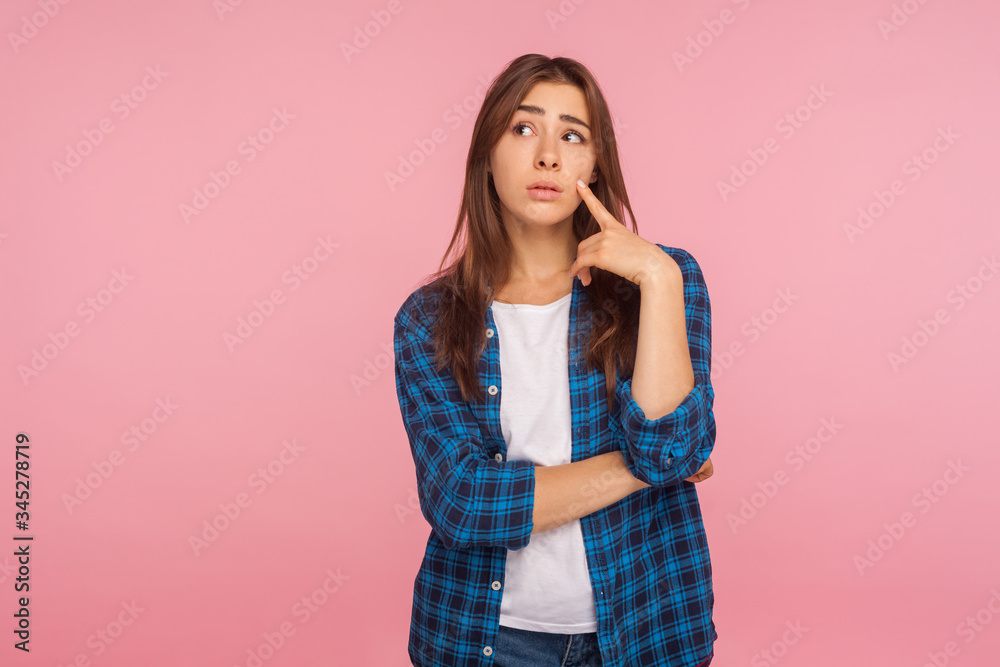 Need to think over difficult decision! Portrait of pensive girl in checkered shirt looking aside with doubtful thoughtful face, pondering intensely concentrating. indoor studio shot, pink background Need to think over difficult decision! Portrait of pensive girl in checkered shirt looking aside with doubtful thoughtful face, pondering intensely concentrating. indoor studio shot, pink background