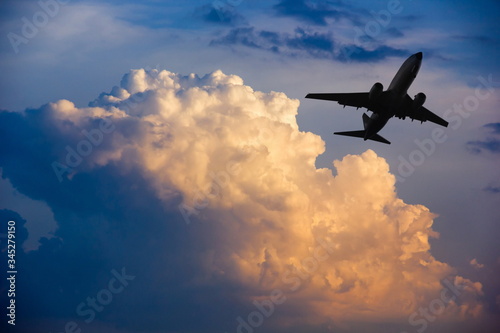 Airplane taking off at sunset. Silhouette of a big passenger or cargo aircraft  airline. Transportation