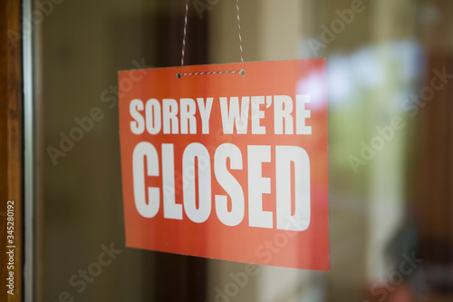 Closed sign board hanging on door of cafe or small store