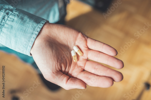 Medicament or cure concept. Close up of male hand with pills.