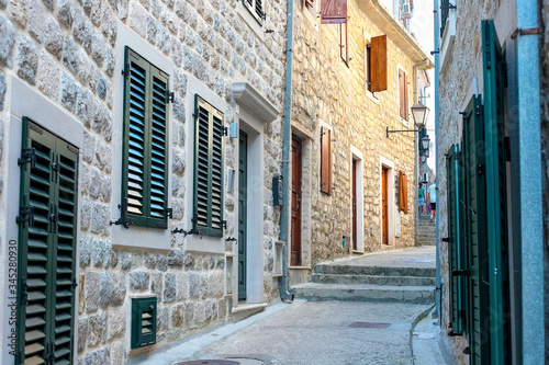 Fototapeta Naklejka Na Ścianę i Meble -  Winding street of the authentic, old town of Herceg Novi, Montenegro. We see old houses and very narrow