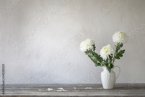 Fototapeta Naklejka Na Ścianę i Meble -  white chrysanthemum in jug on background old wall