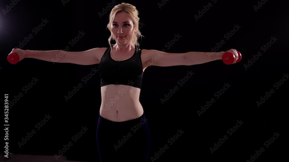 Beautiful blonde woman sports with fitness dumbbells