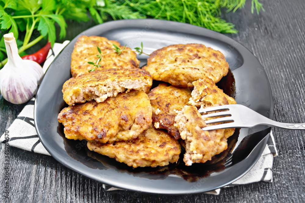 Fritters meat in black plate on wooden board Fritters meat in black plate on wooden board