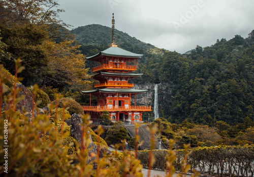 Mystical view over the ancient building and the huge waterfall at Kumano Nachi taisha, on the famous stone path Kumano Kodo pilgrimage route photo