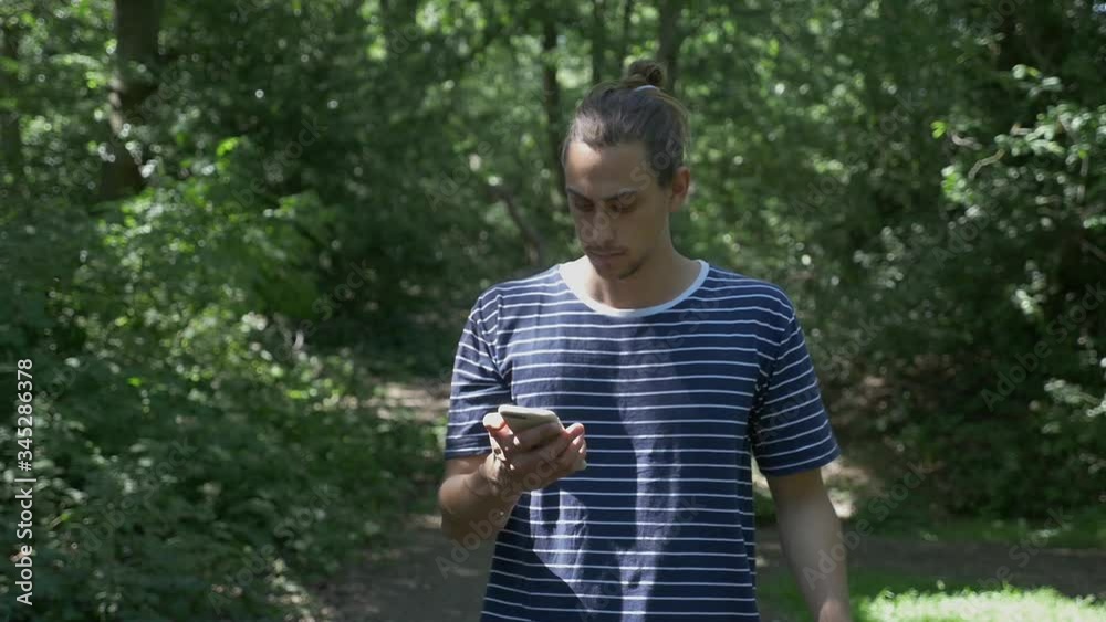 Handsome male reacting negatively towards a text message on his mobile phone Handsome male reacting negatively towards a text message on his mobile phone