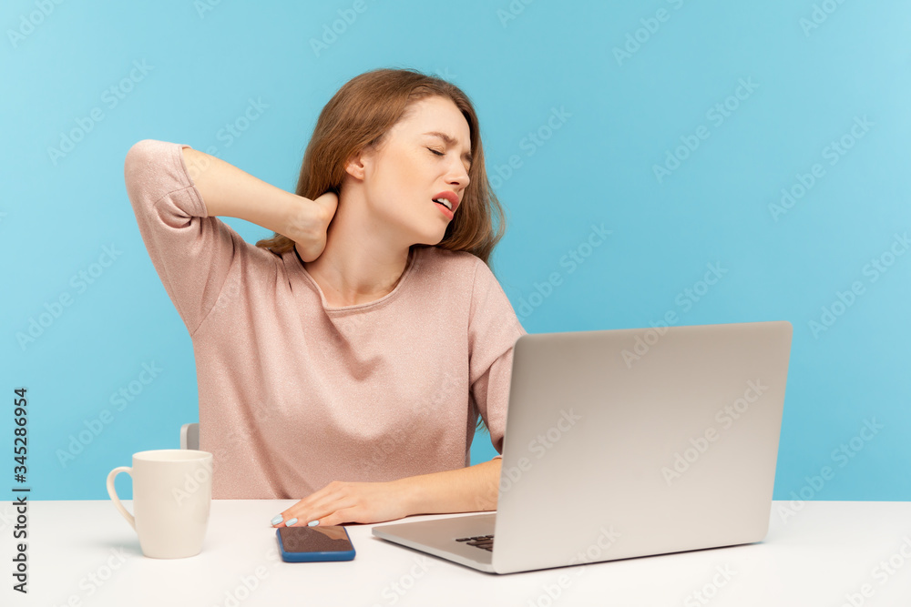Sick young woman employee sitting at workplace with laptop feeling