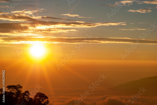 The morning sun rising, there were clouds and mountain peaks against a blurred patterned background.