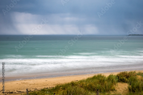 Paysage de vagues, plage, dune et ciel avec grain à Plouharnel en pose longue - Morbihan photo