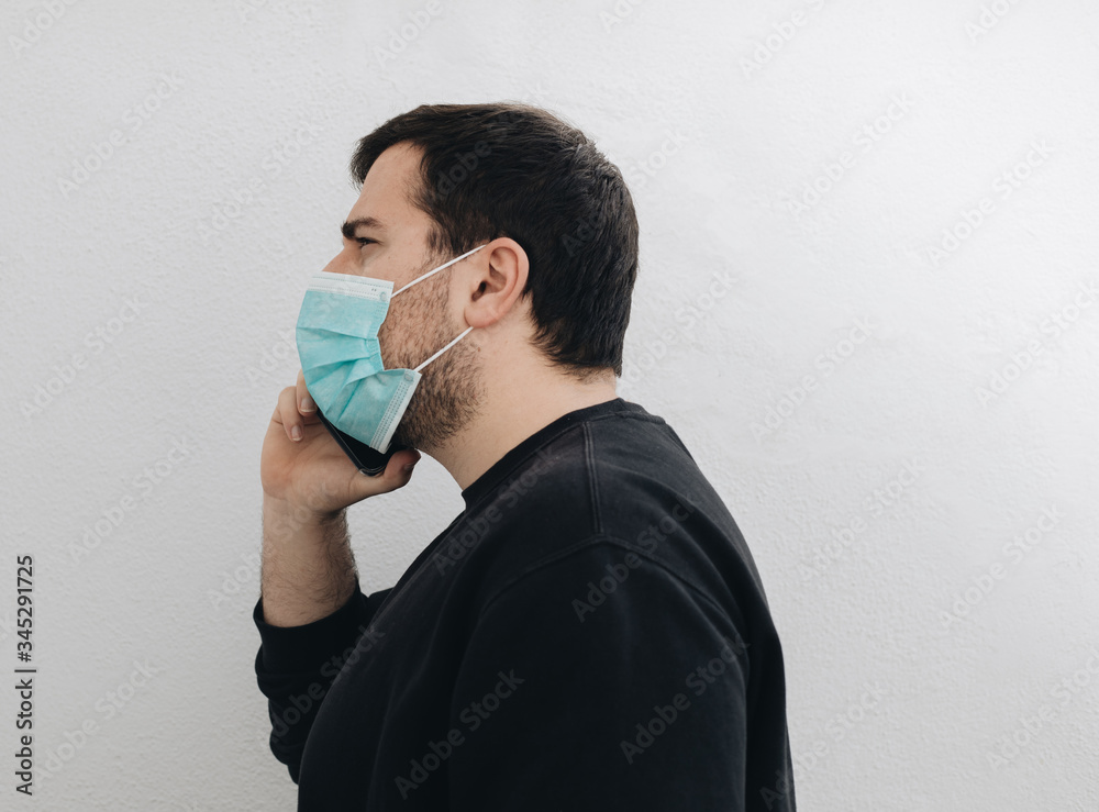 Man is talking with his phone and a medical mask. Man is talking with his phone and a medical mask.