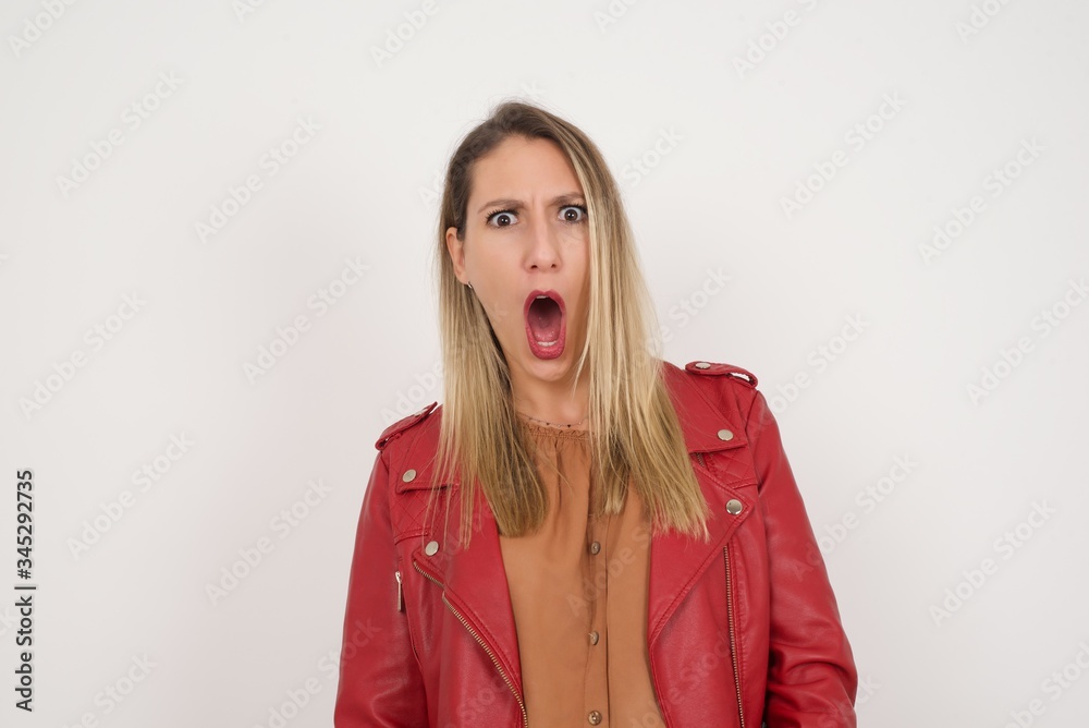 Expressive facial expressions. Shocked stupefied female, keeps jaw dropped, feels stunned from what she sees aside on blank gray Wall Expressive facial expressions. Shocked stupefied female, keeps jaw dropped, feels stunned from what she sees aside on blank gray Wall