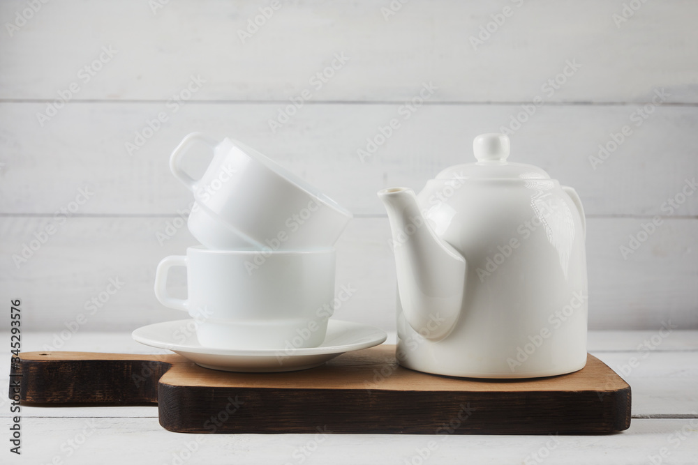 Cup of tea, teapot, oak cutting board on white wooden background. Rustic style concept Cup of tea, teapot, oak cutting board on white wooden background. Rustic style concept