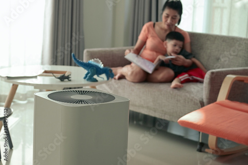 air purifier in living room with mother and kid reading inside home