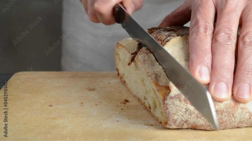 Chef cutting organic sourdough bread with type 0 wheat flour.
