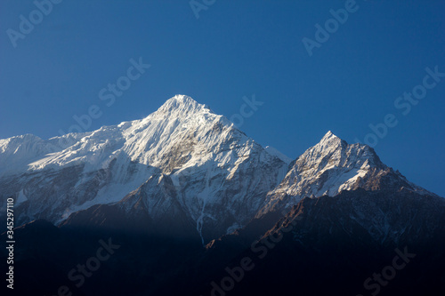 Spectacular view of very high snowy mountains with a beautiful blue sky in Annapurnas, Nepal. Nilgiri Peak, trekking round the annapurnas