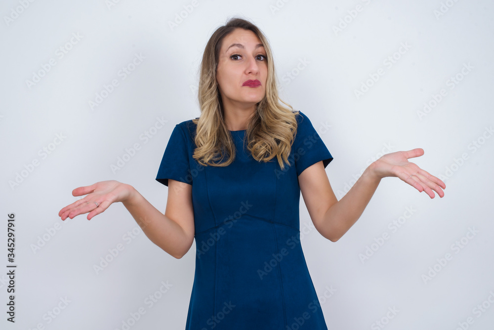 Puzzled and clueless young woman with arms out, shrugging her shoulders, saying: who cares, so what, I don't know. Negative human emotions, facial expressions, life perception and attitude. Puzzled and clueless young woman with arms out, shrugging her shoulders, saying: who cares, so what, I don't know. Negative human emotions, facial expressions, life perception and attitude.