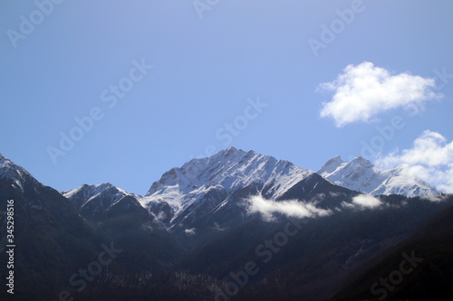 Nanjiabawa  one of the ten most beautiful mountains in China  is hidden between the blue sky and white clouds. No one has reached the summit so far 