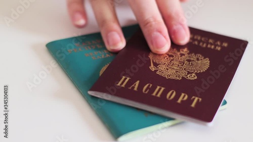 Passports of Russia and Kazakhstan, border countries. Hand puts passports on the table