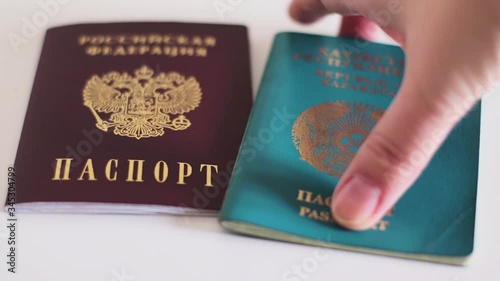 Passports of Russia and Kazakhstan, border countries. Hand takes passports from the table