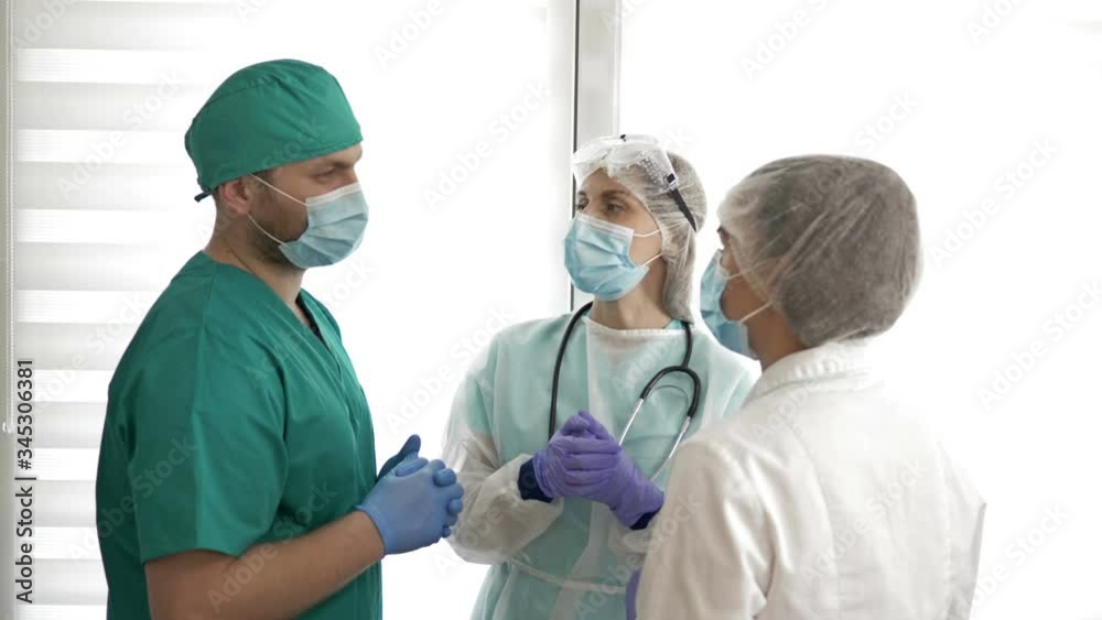Group of doctors in protective suits are discussing medical issues. Group of doctors in protective suits are discussing medical issues.