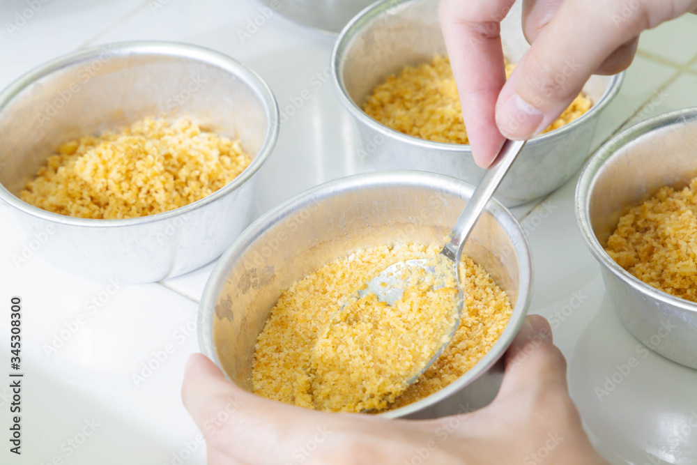 Closeup of spoon smashed crispy cracker in mould pan to make base of blueberry cheesecake. Process of cooking food. Homemade bakery. selective focus