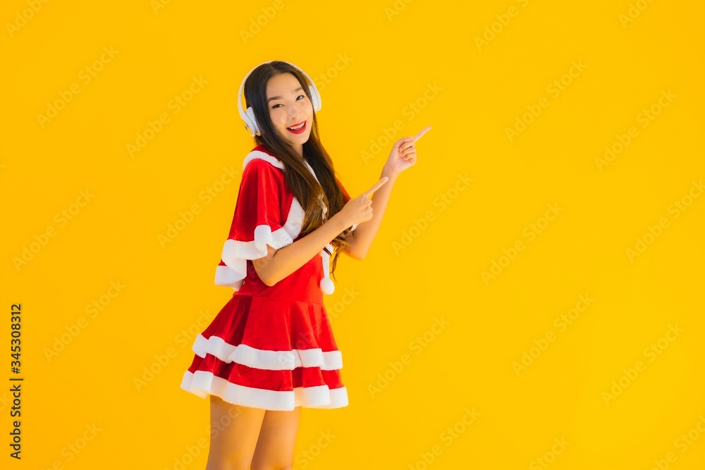 Portrait beautiful young asian christmas clothes and hat listen for music Portrait beautiful young asian christmas clothes and hat listen for music