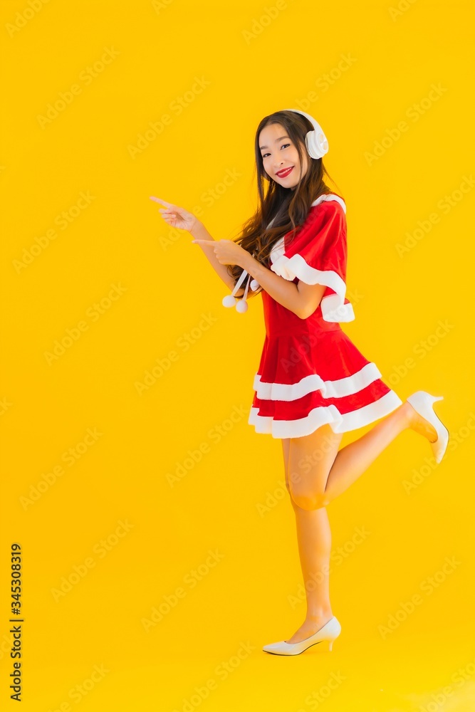 Portrait beautiful young asian christmas clothes and hat listen for music Portrait beautiful young asian christmas clothes and hat listen for music