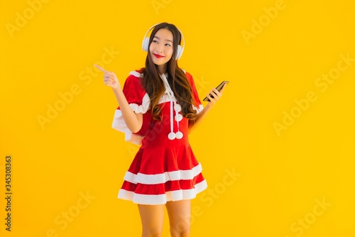 Portrait beautiful young asian christmas clothes and hat listen for music
