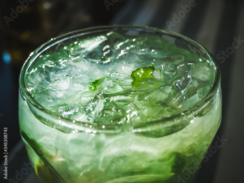 mojito cocktail with lime slices, mint leaves and ice closeup