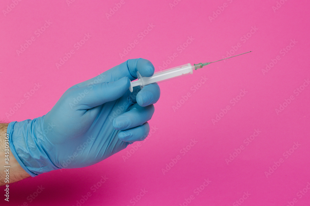 hand with latex gloves and syringe on pink background hand with latex gloves and syringe on pink background
