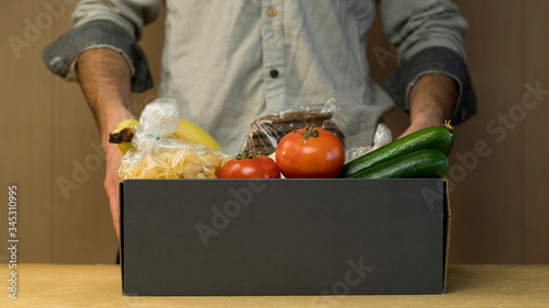 Fotografija Donation box with food in the mens hands