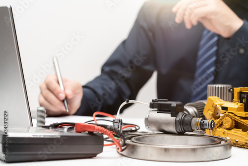 solenoid valve on the working table of mechanic man in office, repair maintenance heavy machinery concept