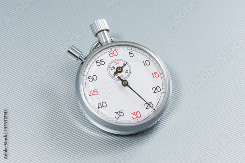 Analogue metal stopwatch on the gray background.