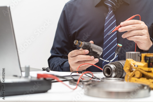 Photos Professional engineer inspec solenoid valve for during working day in office, re