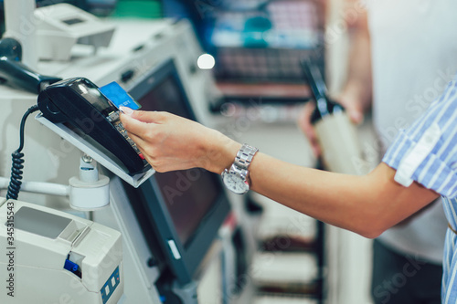 Fotografie Couple with bank card buying food at grocery store or supermarket self-checkout