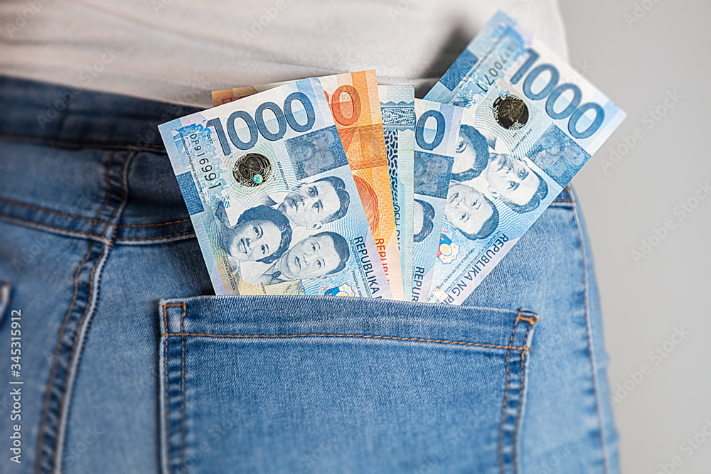 Zdjęcie Stock Philippines Peso in a female pants pocket. Philippine pesos notes stuck in a