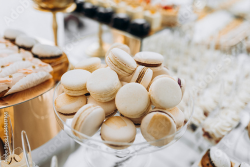 Macarons with chocolate. Sweet table with macaroons. Candy bar or dessert table with macarons and other sweets.