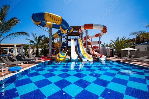 Colorful waterpark tubes and pool in tropical aquapark
