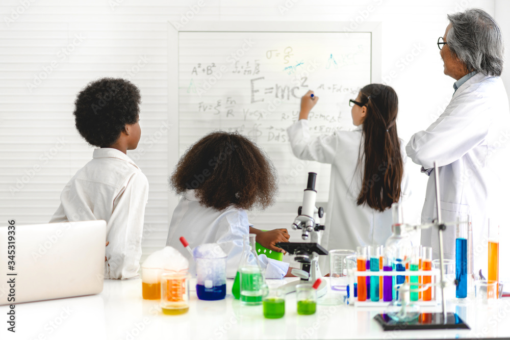 Group of teenage students learning and doing a chemical experiment teacher in the experiment laboratory class on table at school.Education concept Group of teenage students learning and doing a chemical experiment teacher in the experiment laboratory class on table at school.Education concept