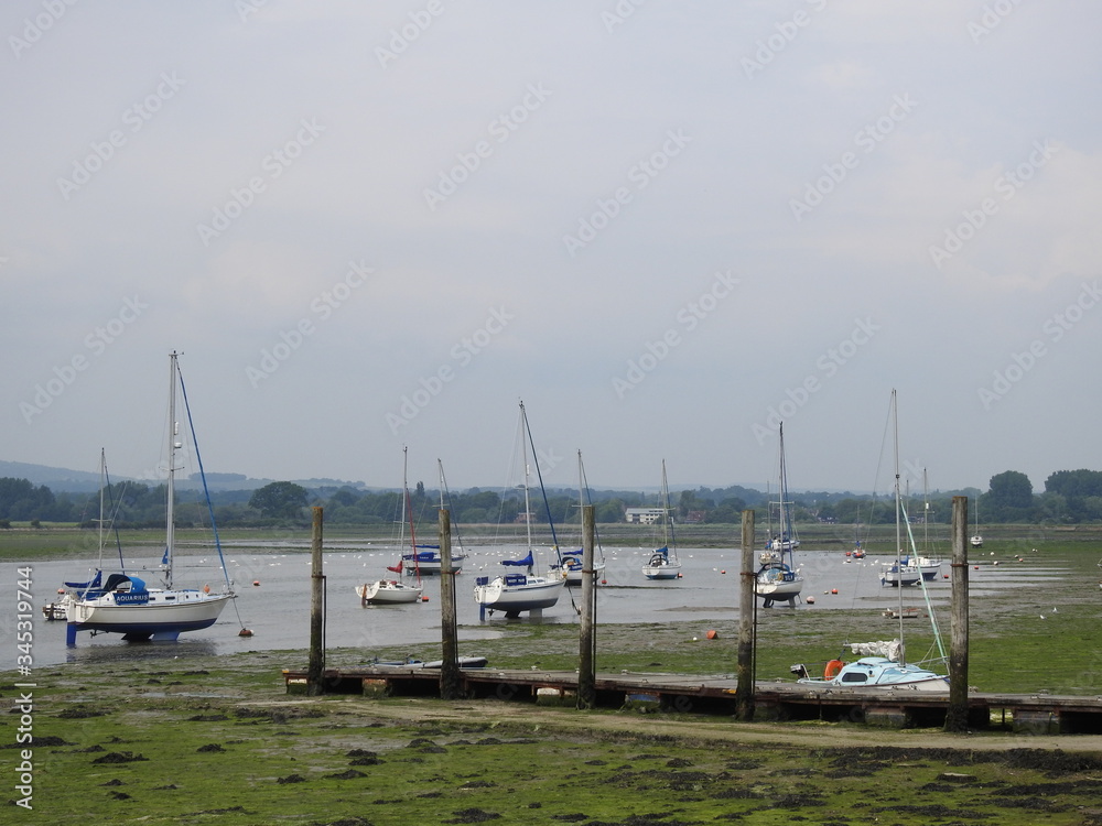 Sailboats are standing in a bay with a small amount of water