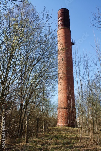 Old brick tower lighthouse from Chernobyl among dry trees. Stalker entry into the exclusion zone, an abandoned city, ruins and a radio zone. Observation tower in a dry autumn forest.