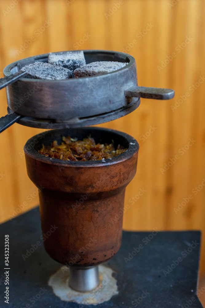 Hookah with a bowl and charcoal on the wooden background Hookah with a bowl and charcoal on the wooden background