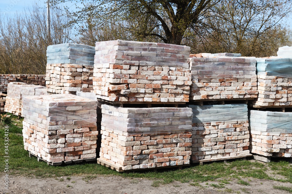 Piles of restored bricks on pallets, outdoors.Construction Materials.
