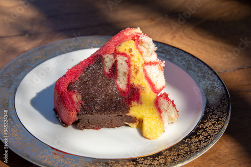 Photos Close up of a slice of beautiful italian dessert, the Zuppa Inglese dessert, a trifle cake with chocolate and vanilla cream fillings and red Alchermesspirit