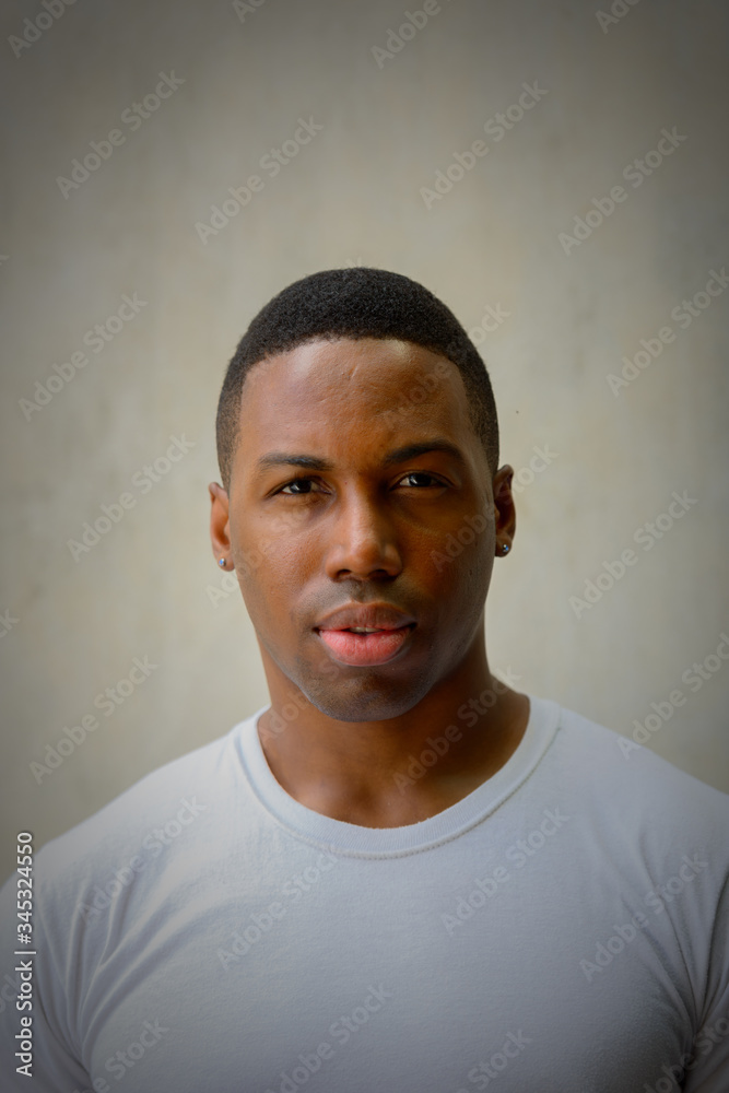 Face of young handsome African man against concrete wall Face of young handsome African man against concrete wall
