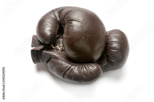 Old brown boxing gloves with rope lacing isolated on white background