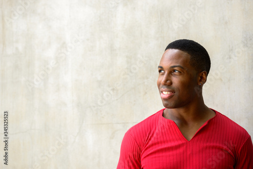 Face of happy young handsome African man thinking © Ranta Images