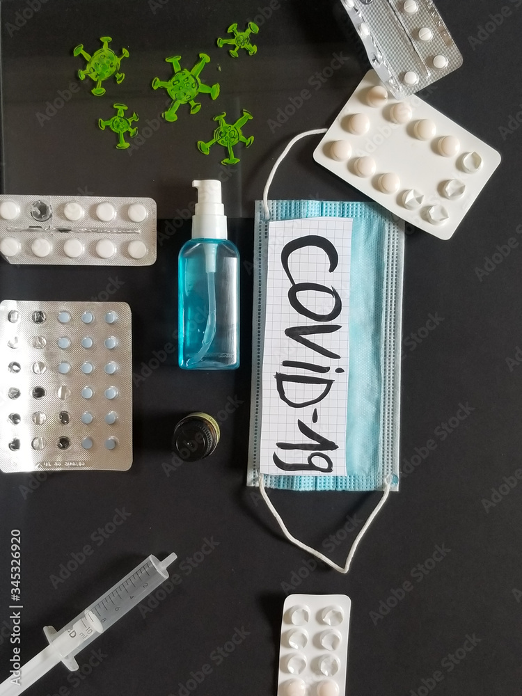 one medical protective mask, antiseptic, pills, vitamins, vaccine isolated on black background. Disposable surgical face mask covers the mouth and nose. Coronavirus quarantine, covid-19 protection one medical protective mask, antiseptic, pills, vitamins, vaccine isolated on black background. Disposable surgical face mask covers the mouth and nose. Coronavirus quarantine, covid-19 protection
