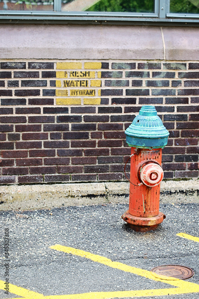 Brick wall with a red fire hydrant in front of it Brick wall with a red fire hydrant in front of it